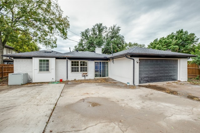 ranch-style house featuring a garage and central AC unit