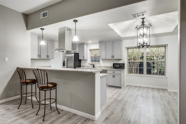 kitchen with kitchen peninsula, stainless steel appliances, extractor fan, and a wealth of natural light