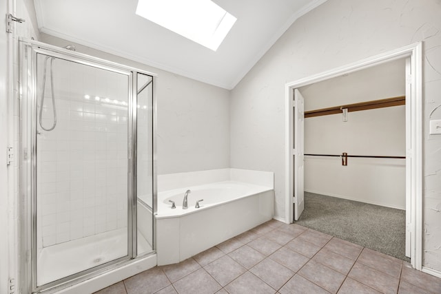 bathroom featuring tile patterned flooring, shower with separate bathtub, ornamental molding, and vaulted ceiling with skylight