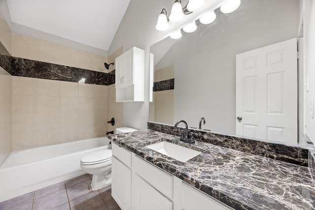 full bathroom with vanity, tile patterned floors, tiled shower / bath, vaulted ceiling, and toilet