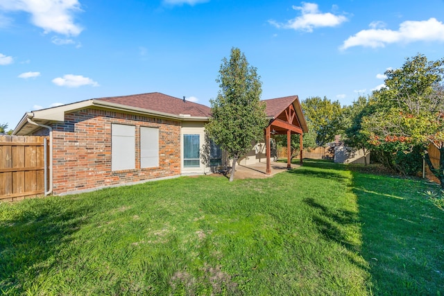 rear view of property featuring a lawn and a patio area