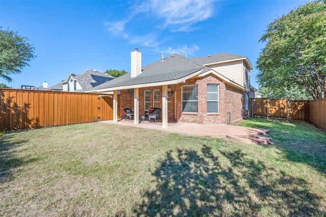 back of property featuring a lawn and a patio