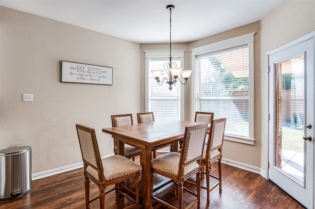 dining space with dark hardwood / wood-style flooring and an inviting chandelier