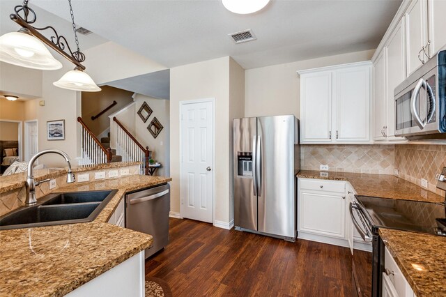 kitchen with white cabinets, decorative light fixtures, sink, and stainless steel appliances