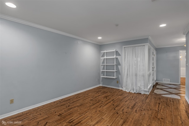 spare room featuring crown molding and hardwood / wood-style floors