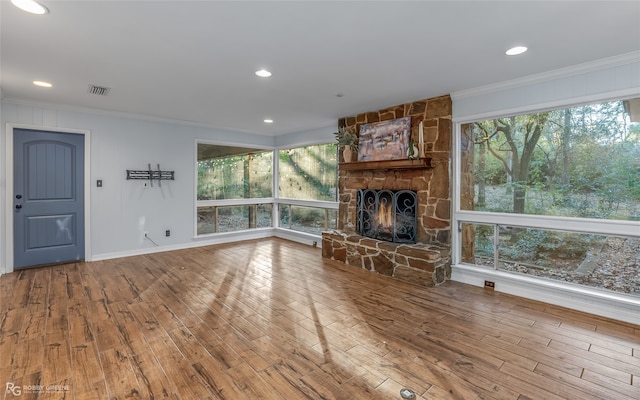 unfurnished living room with a fireplace, wood-type flooring, and crown molding