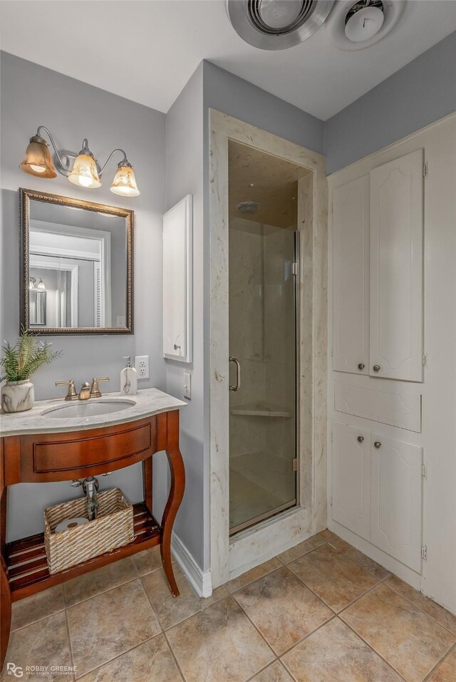 bathroom featuring tile patterned flooring, vanity, and a shower with shower door