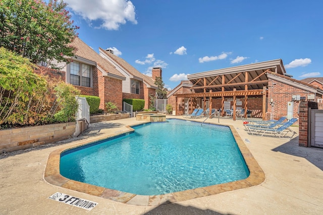 view of swimming pool featuring a patio area and a community hot tub