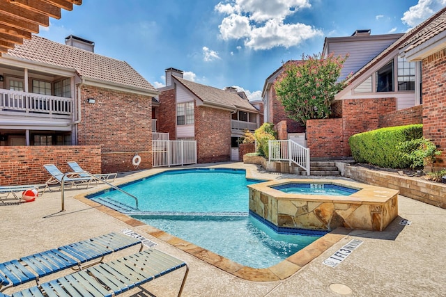 view of swimming pool featuring a community hot tub