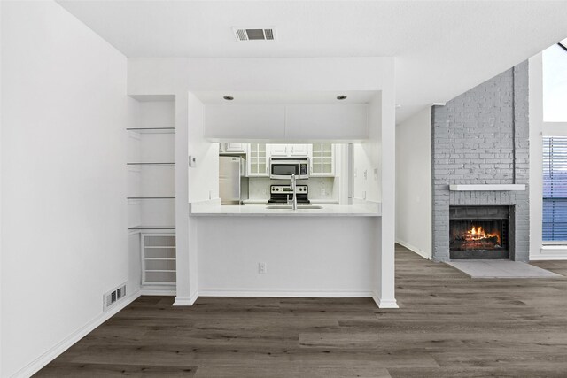 unfurnished living room featuring ceiling fan, dark hardwood / wood-style floors, sink, and vaulted ceiling