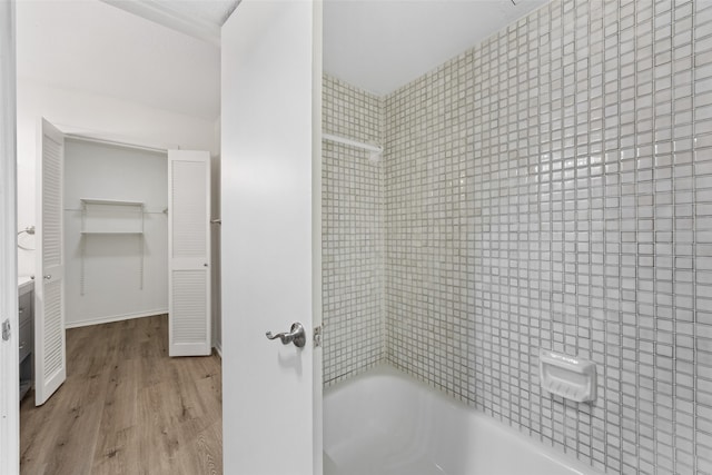 bathroom featuring tiled shower / bath combo and hardwood / wood-style flooring