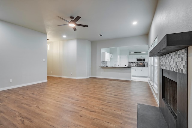 unfurnished living room with ceiling fan and light hardwood / wood-style flooring