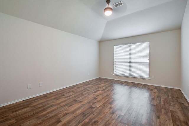 unfurnished room with dark wood-type flooring and lofted ceiling