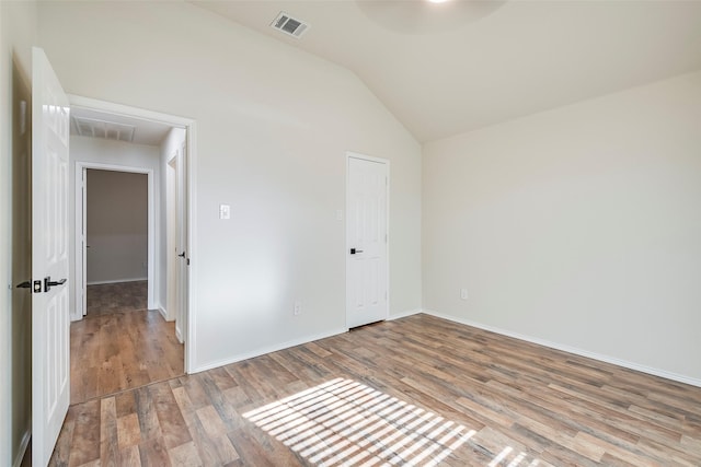 unfurnished room featuring lofted ceiling and light hardwood / wood-style flooring