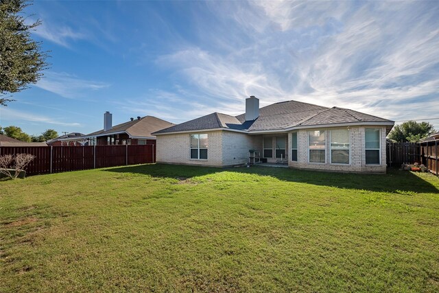 back of property featuring a lawn