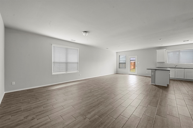 unfurnished living room with light hardwood / wood-style floors and sink