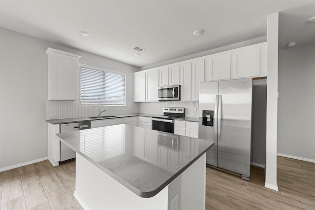 kitchen with white cabinetry, a kitchen island, and appliances with stainless steel finishes