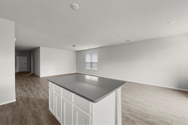 kitchen featuring white cabinetry, a center island, and light wood-type flooring