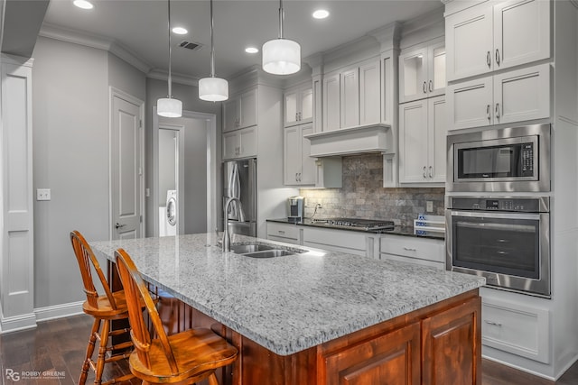 kitchen with a center island with sink, sink, and appliances with stainless steel finishes