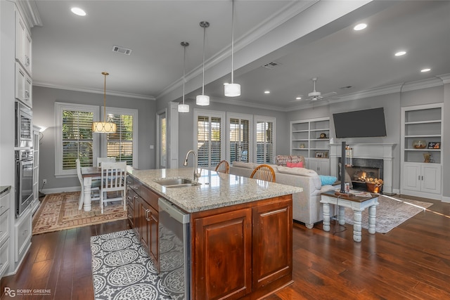 kitchen with a sink, visible vents, appliances with stainless steel finishes, a wealth of natural light, and light stone countertops