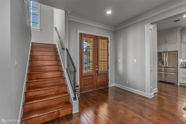 entrance foyer with baseboards, visible vents, dark wood finished floors, stairs, and crown molding