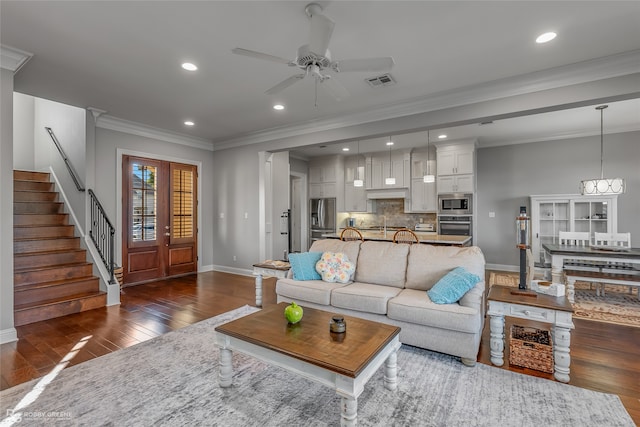 living room with crown molding, ceiling fan with notable chandelier, and dark hardwood / wood-style floors