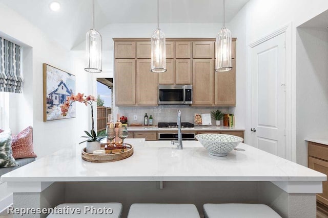 kitchen with tasteful backsplash, vaulted ceiling, hanging light fixtures, and a kitchen island with sink