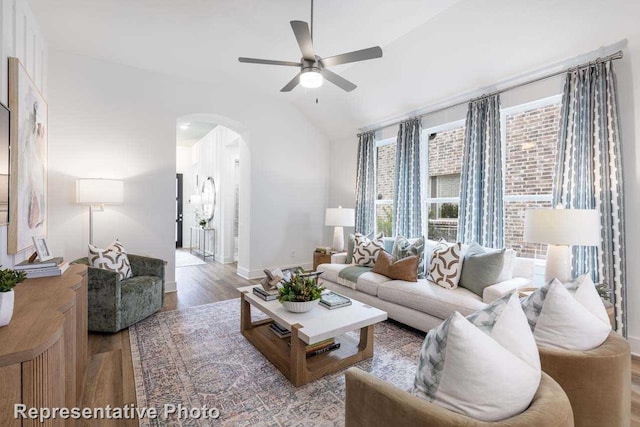 living room featuring light hardwood / wood-style flooring, vaulted ceiling, and ceiling fan