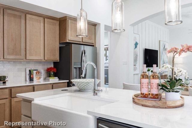 kitchen featuring decorative backsplash, stainless steel fridge with ice dispenser, decorative light fixtures, and sink