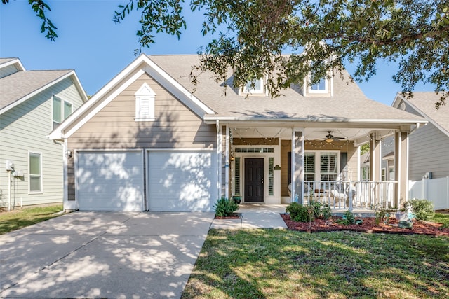 view of front of house with ceiling fan, a porch, a garage, and a front lawn