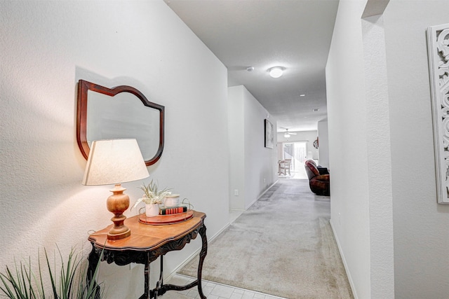 hallway featuring light colored carpet