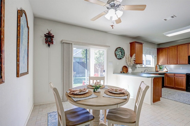 dining space featuring ceiling fan and sink