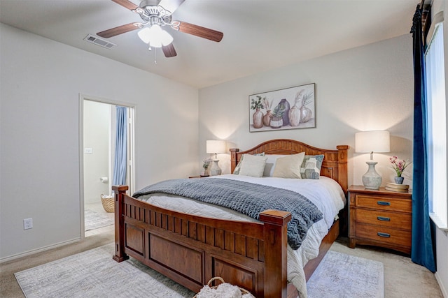 bedroom featuring ceiling fan, ensuite bathroom, light carpet, and multiple windows