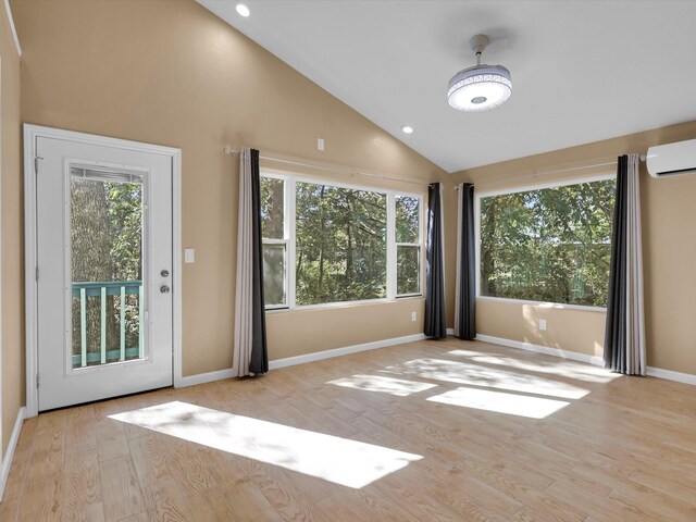 spare room featuring recessed lighting, a wall unit AC, baseboards, and wood finished floors