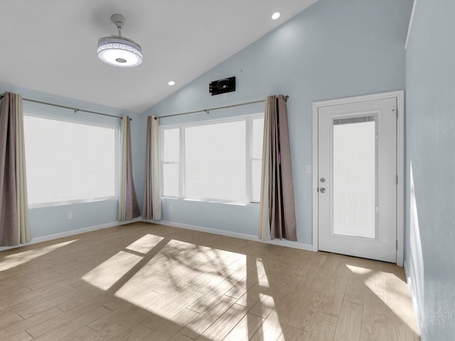 unfurnished room featuring high vaulted ceiling and light hardwood / wood-style flooring