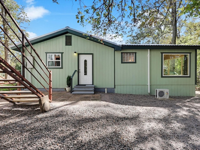 view of front of property featuring entry steps, metal roof, and ac unit