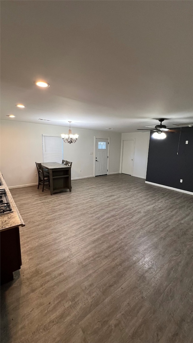 living room featuring dark hardwood / wood-style flooring and ceiling fan with notable chandelier