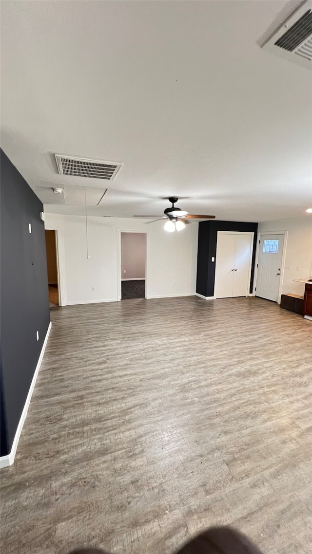 unfurnished living room with wood-type flooring and ceiling fan