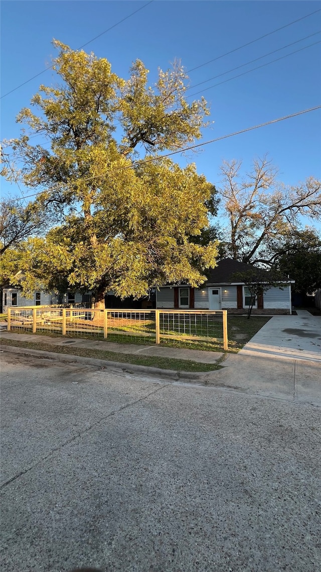 view of property hidden behind natural elements with a front yard