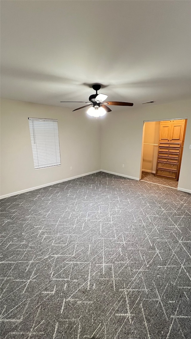 carpeted empty room featuring ceiling fan