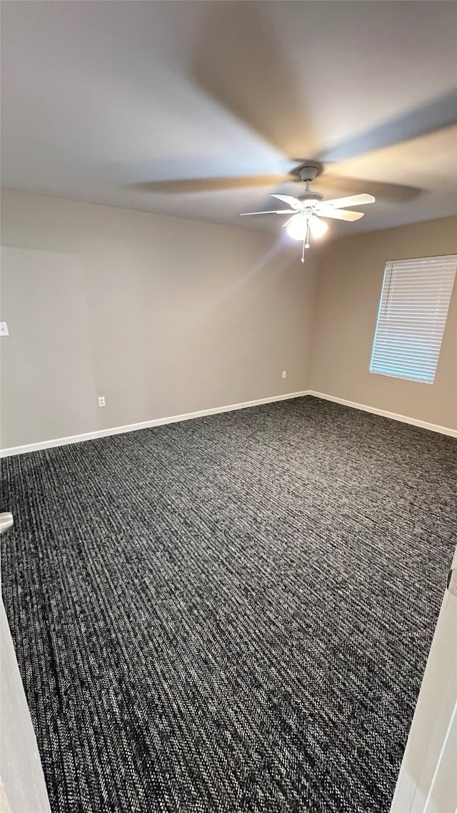 unfurnished room featuring ceiling fan and carpet