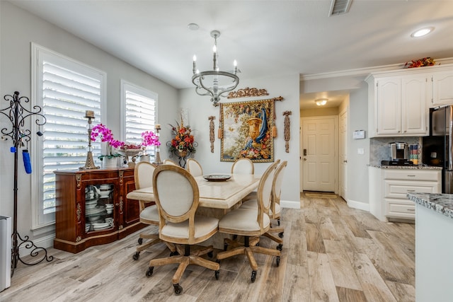 dining area featuring a notable chandelier and light wood-type flooring