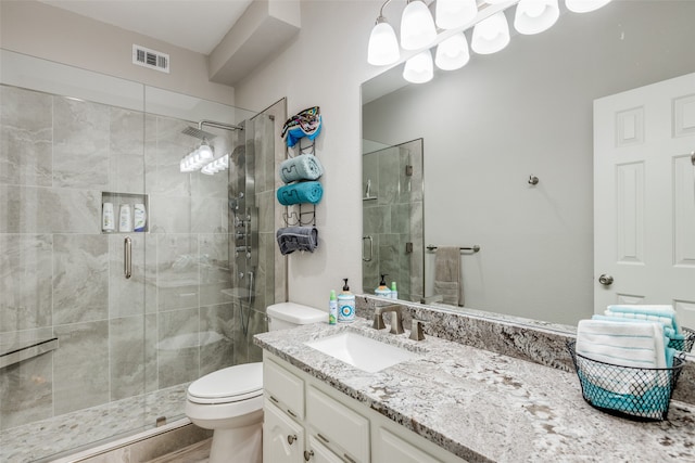 bathroom featuring vanity, toilet, and a shower with door