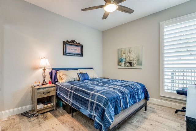 bedroom with hardwood / wood-style flooring, multiple windows, and ceiling fan