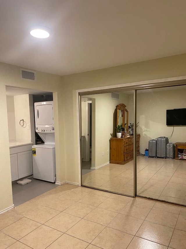 bedroom featuring a closet and stacked washer / drying machine