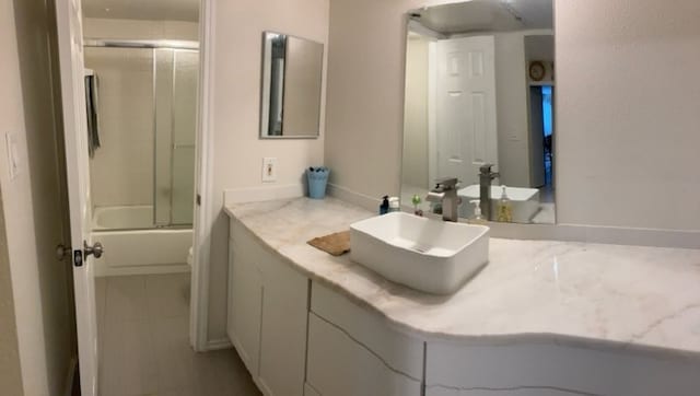 bathroom featuring vanity and bath / shower combo with glass door