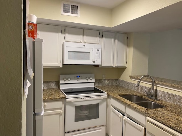 kitchen featuring white cabinetry, white appliances, sink, and dark stone counters