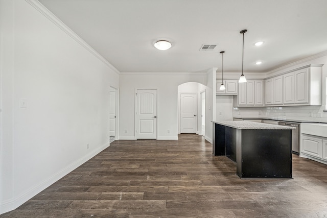 kitchen featuring a center island, dark hardwood / wood-style flooring, decorative light fixtures, decorative backsplash, and ornamental molding