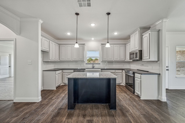 kitchen featuring gray cabinetry, a kitchen island, dark hardwood / wood-style flooring, and appliances with stainless steel finishes