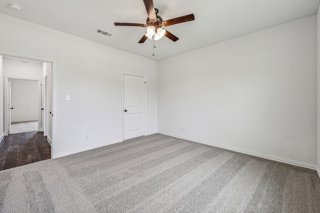 spare room with ceiling fan and dark carpet